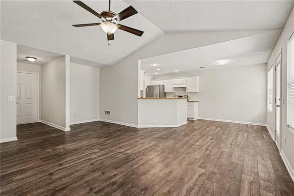 a view of a kitchen with wooden floor and a ceiling fan