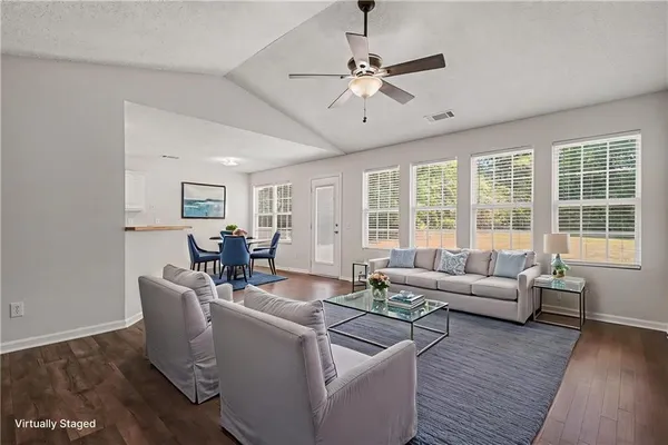 a living room with furniture and floor to ceiling windows