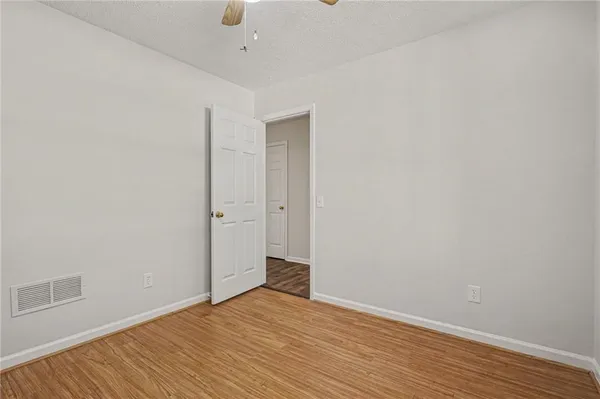 a view of an empty room with wooden floor