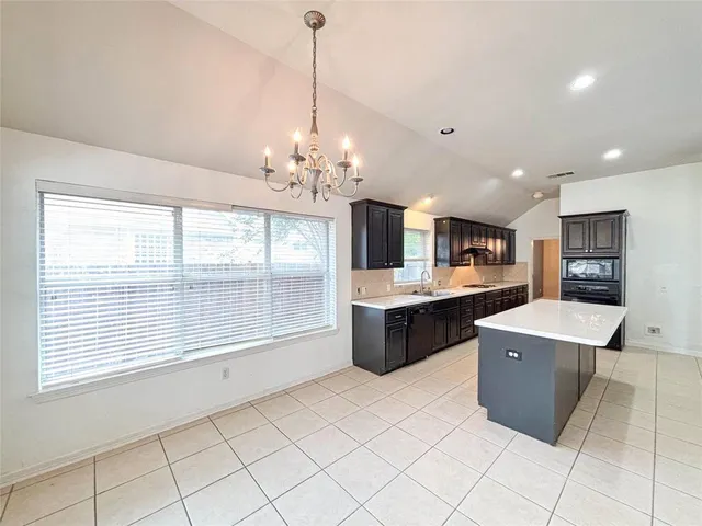 a living room with kitchen island furniture and a chandelier