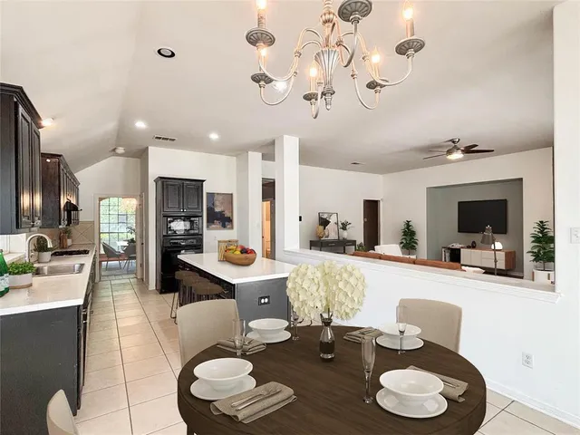 a living room with furniture kitchen view and a chandelier