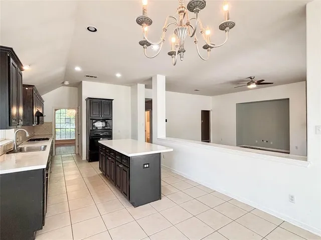 a large white kitchen with a large counter top appliances and cabinets