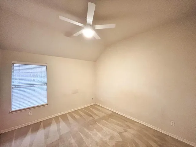 an empty room with a ceiling fan and wooden floor
