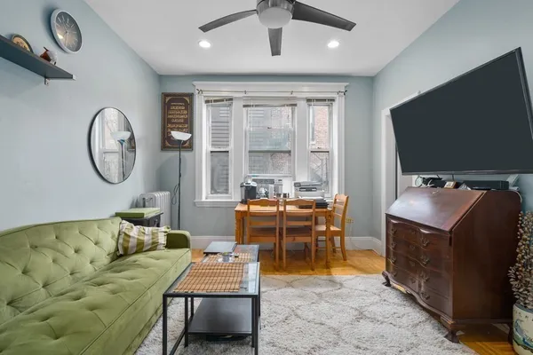 a living room with furniture a flat screen tv and a large window