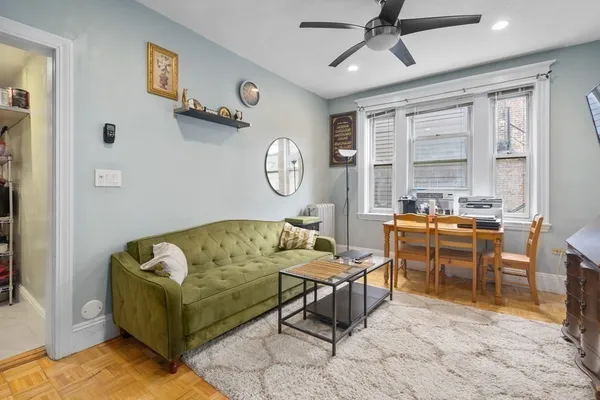 a living room with furniture kitchen view and a large window