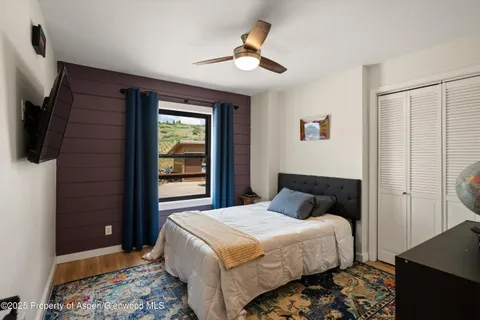 a bedroom with a bed and a flat screen tv