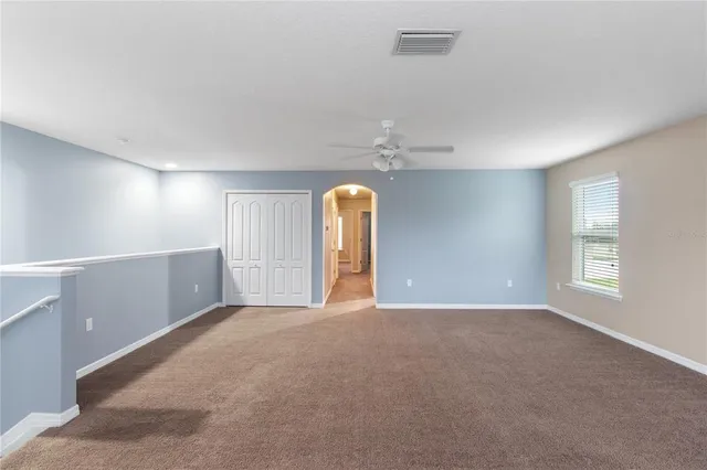 a view of an empty room with a chandelier fan