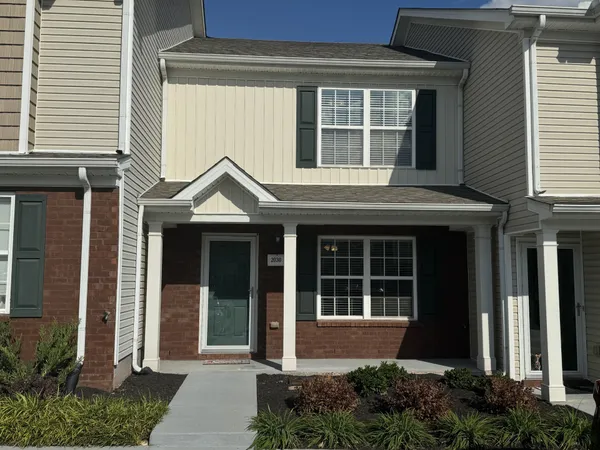 a front view of a house with a yard and glass windows