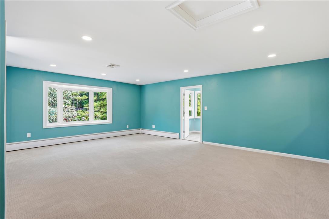 6271 Batman Road Zionsville, PA 18092 - Photo 49 of 100 A spacious room with serene blue walls offers tranquil views of lush greenery through a charming bay window.