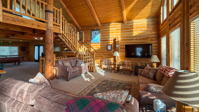 143 East Chestnut Street Helper, UT 84526 - Photo 4 of 35 Living area with log walls, a high wooden beamed ceiling, carpet flooring, and plenty of natural light