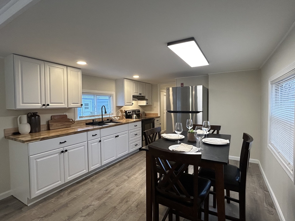 229 Miller Street, Unit D6 Ludlow, MA 01056 - Photo 3 of 24 a kitchen with a dining table chairs and white appliances