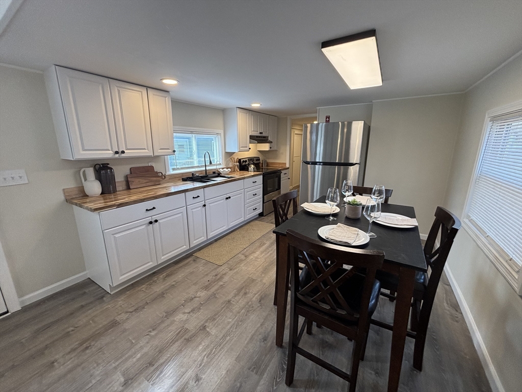 229 Miller Street, Unit D6 Ludlow, MA 01056 - Photo 4 of 24 a kitchen with granite countertop a dining table chairs and wooden floor