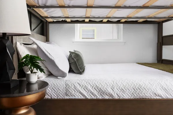 a bedroom with a bed and a potted plant