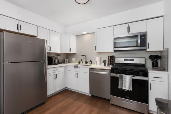a kitchen with stainless steel appliances granite countertop a refrigerator stove a sink and a microwave