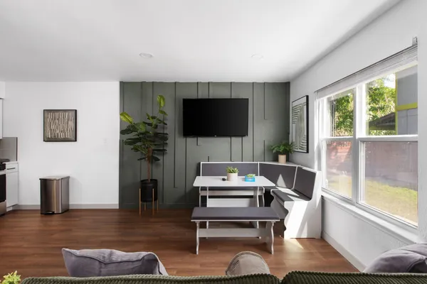a living room with furniture a flat screen tv and a large window