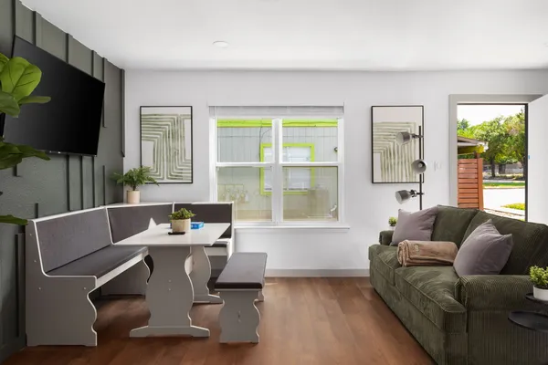 a living room with furniture a flat screen tv and a window