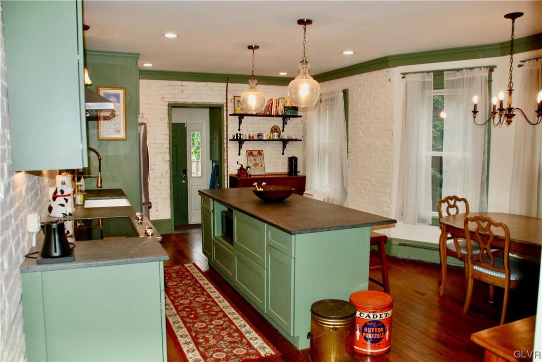 30 North 5th Street Emmaus, PA 18049 - Photo 5 of 20 a kitchen with stainless steel appliances kitchen island granite countertop a table chairs in it and a wooden floor