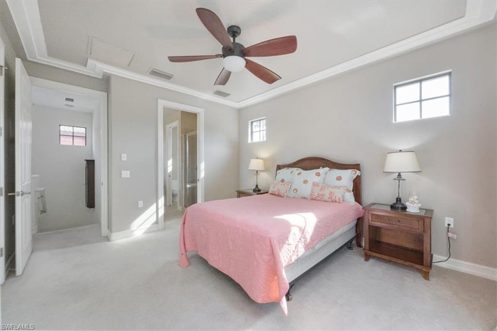 9111 Chula Vista Street, Unit 11604 Naples, FL 34113 - Photo 17 of 33 a bedroom with a bed and a ceiling fan