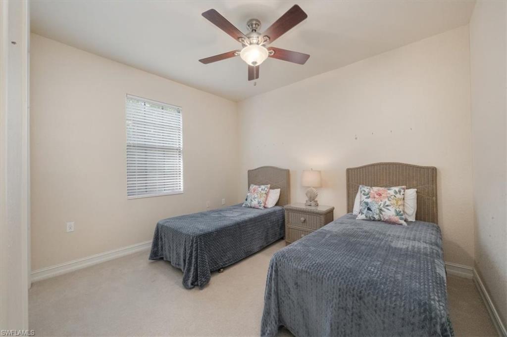 9111 Chula Vista Street, Unit 11604 Naples, FL 34113 - Photo 20 of 33 a bedroom with two beds and a chandelier