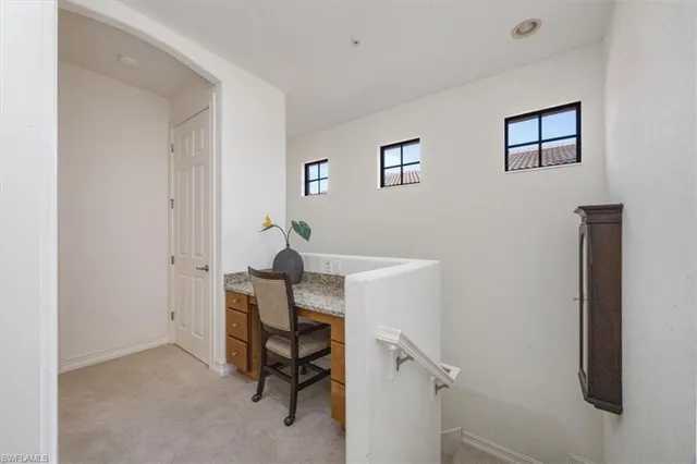 a view of a workspace with furniture and a window