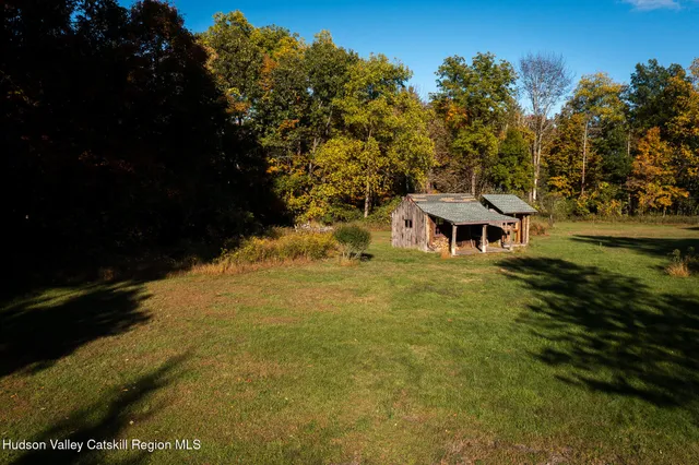 a view of a swimming pool with a table and chairs under an umbrella