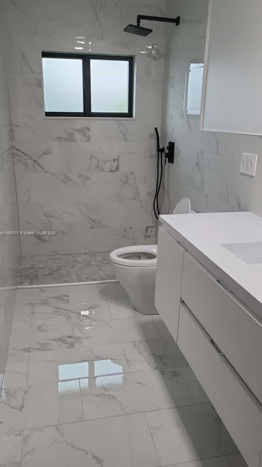 1236 North Hiatus Road, Unit 1236 Pembroke Pines, FL 33026 - Photo 3 of 19 a bathroom with a toilet a sink and mirror