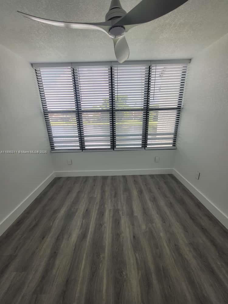 1236 North Hiatus Road, Unit 1236 Pembroke Pines, FL 33026 - Photo 5 of 19 an empty room with wooden floor and windows
