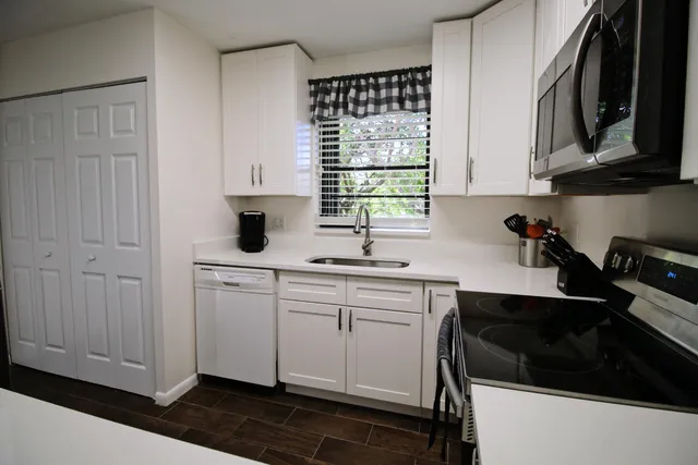 a kitchen with stainless steel appliances a sink stove and cabinets