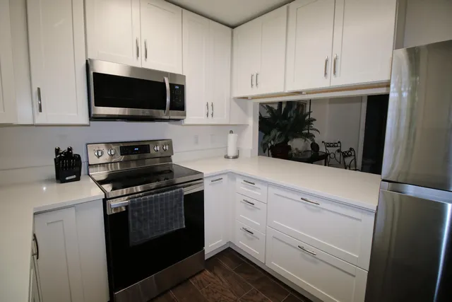 a kitchen with white cabinets and stainless steel appliances