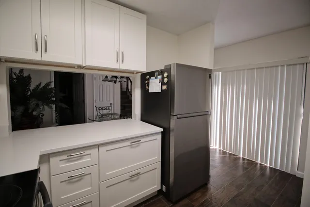 a kitchen with refrigerator and cabinets