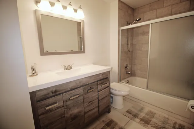 a bathroom with a double vanity sink mirror and toilet