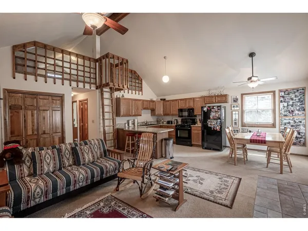 a living room with furniture kitchen view and a chandelier
