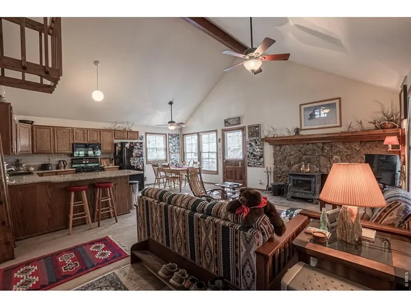 a living room with furniture a rug and kitchen view