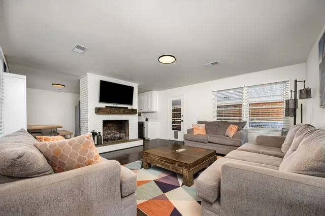 a living room with furniture a fireplace and a flat screen tv