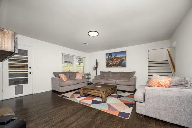 a living room with furniture and a wooden floor