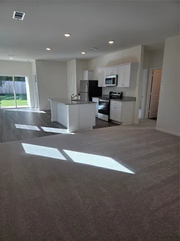 a view of kitchen with stainless steel appliances refrigerator microwave and cabinets