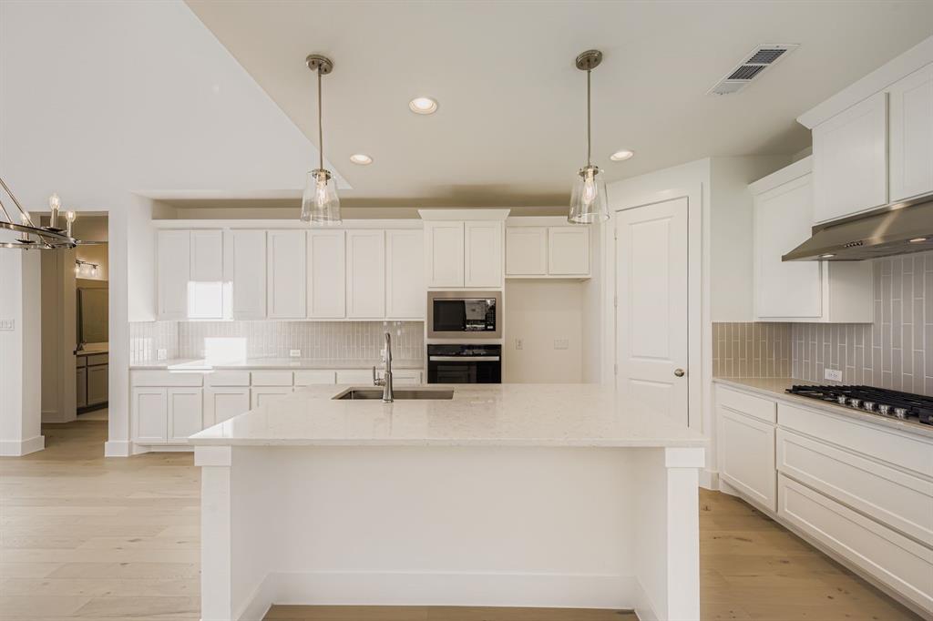 6036 Davis Knoll Road Fort Worth, TX 76126 - Photo 12 of 29 a kitchen with kitchen island white cabinets and stainless steel appliances
