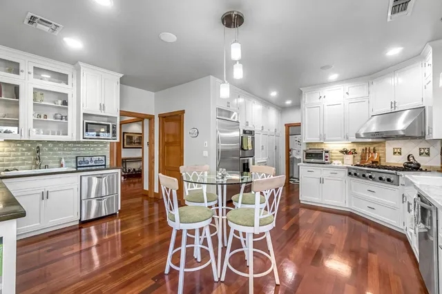 a bathroom with a granite countertop toilet a sink and a mirror