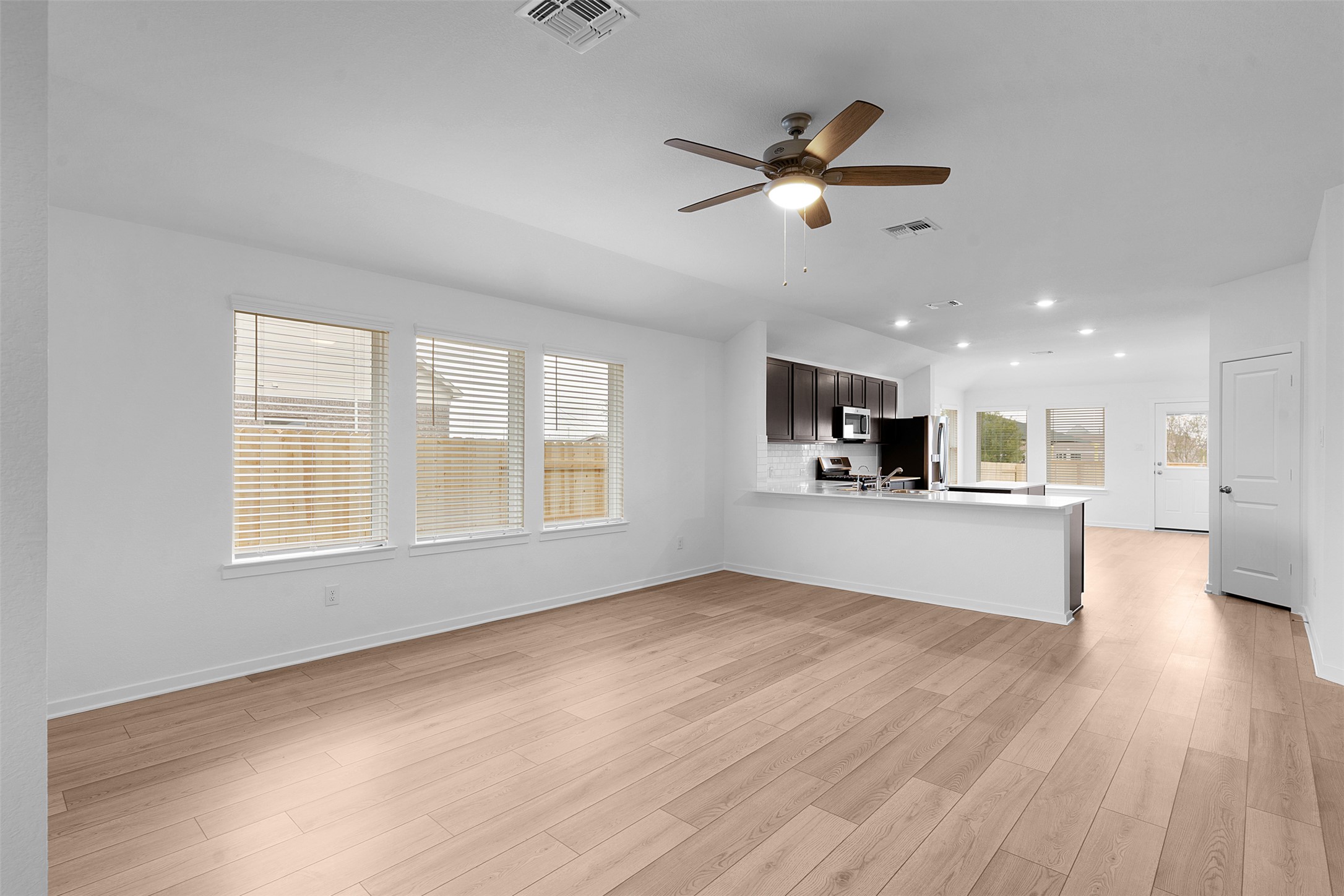 13721 Tucker Hedge Pass Elgin, TX 78621 - Photo 5 of 28 Unfurnished living room featuring light wood-style floors, ceiling fan, and recessed lighting