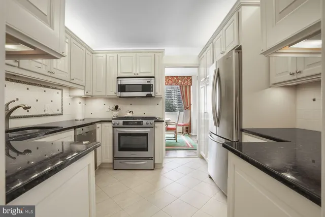 a kitchen with granite countertop a stove sink and cabinets