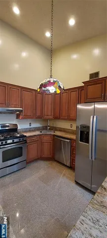 a kitchen with stainless steel appliances a stove a sink and a refrigerator