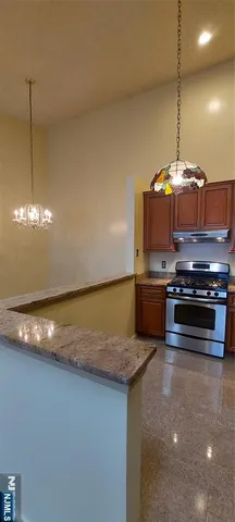 a kitchen with kitchen island a stove a sink and a counter top space