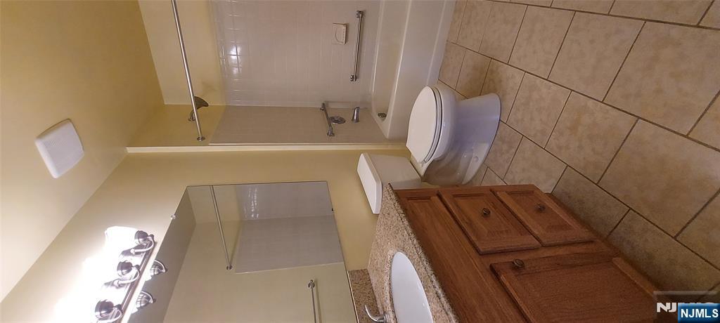 1060 Ash Drive Mahwah, NJ 07430 - Photo 10 of 19 a bathroom with a granite countertop sink a toilet and a mirror