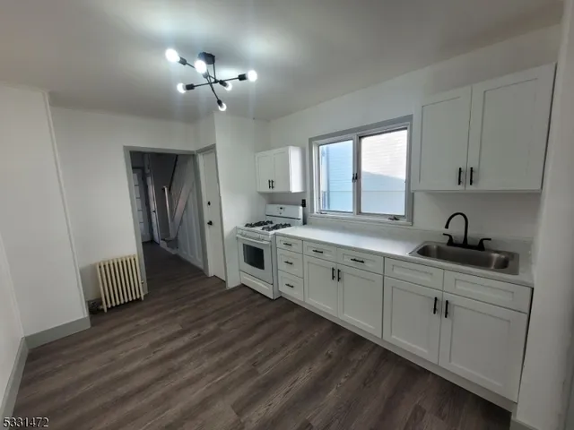 a kitchen with stainless steel appliances a sink dishwasher stove refrigerator and cabinets