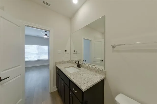 a bathroom with a sink a toilet and vanity