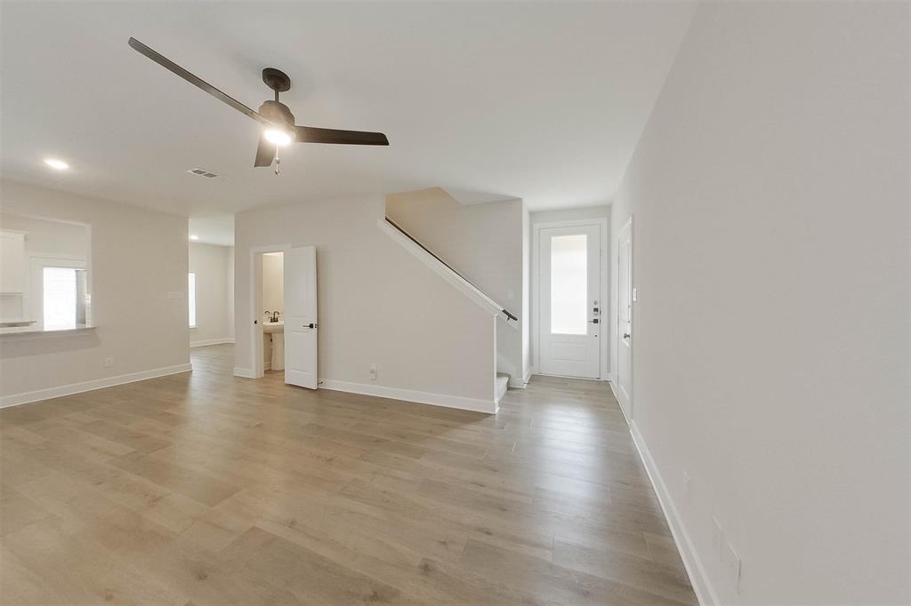 1206 Dye Boulevard Princeton, TX 75407 - Photo 4 of 29 an empty room with wooden floor and windows