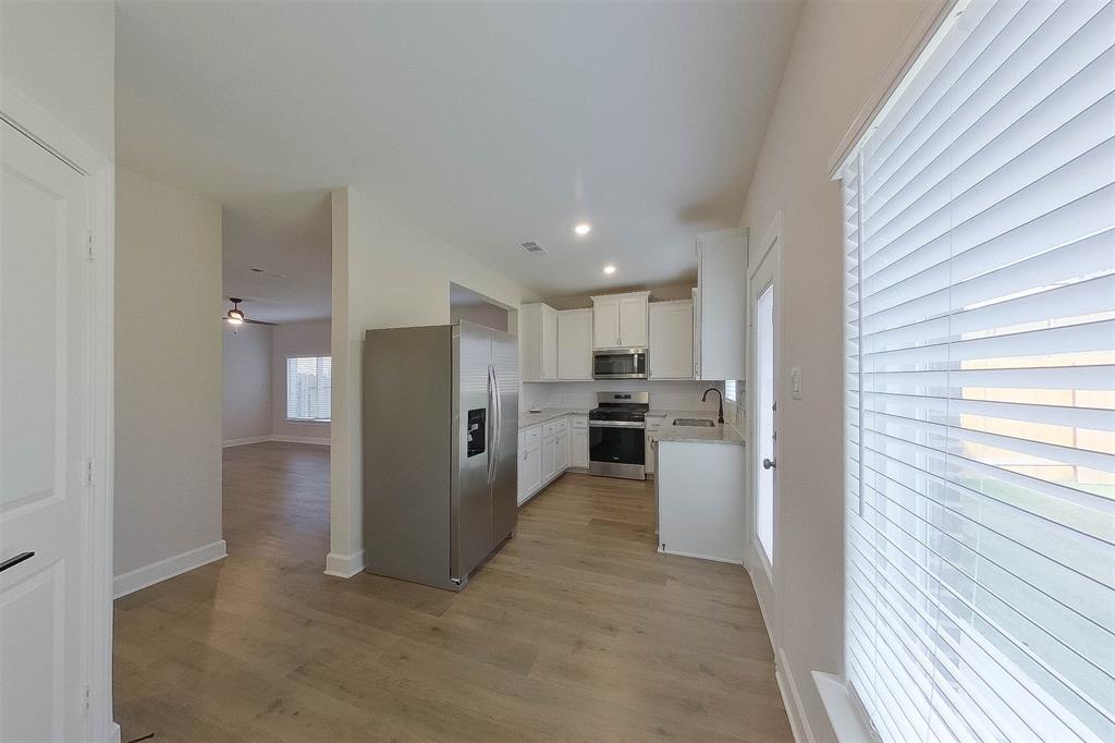 1206 Dye Boulevard Princeton, TX 75407 - Photo 7 of 29 a view of a kitchen with refrigerator and a stove top oven