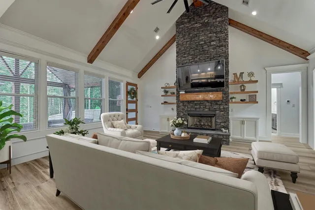 a living room with fireplace furniture and a large window