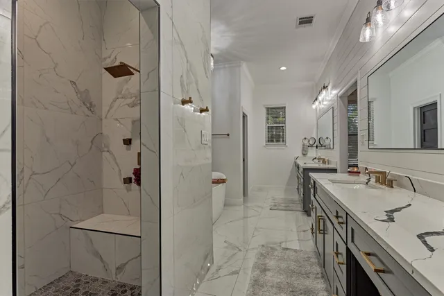 a bathroom with a sink a toilet and shower