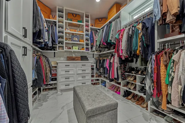 a view of walk in closet with clothes